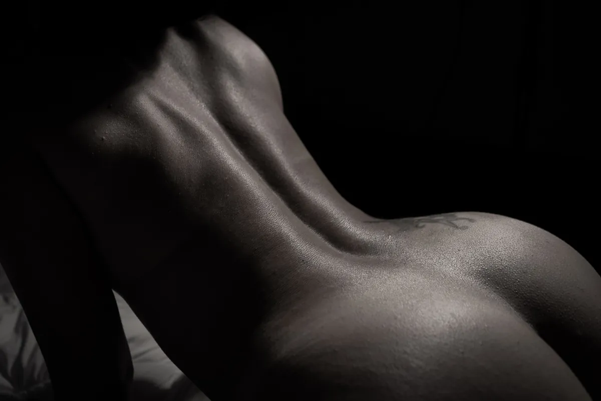 Monochrome bodyscape focusing on a woman's neck, shoulder and collarbone