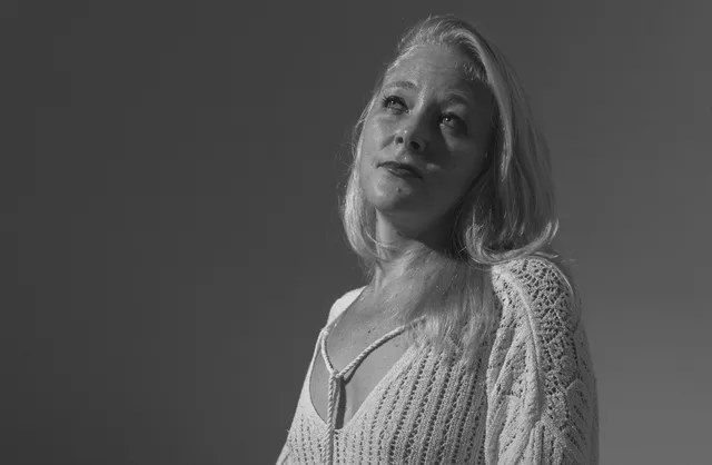 Woman kneeling in white crochet sweater during sexy studio photoshoot in Mauritius