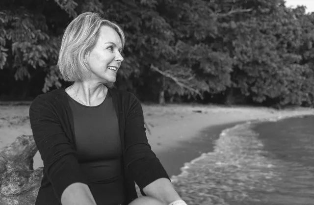 Beachside portrait of woman over 50 embracing natural beauty in Mauritius
