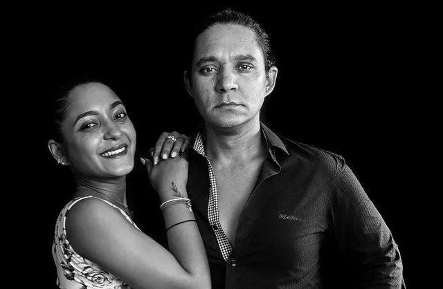 Studio family portrait in black and white with dark backdrop