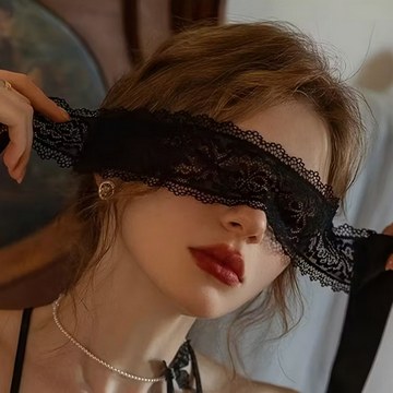 Woman holding a black lace blindfold during an intimate studio photoshoot in Mauritius.