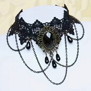 Black lace choker with vintage pendant and hanging chains, displayed as a studio accessory.