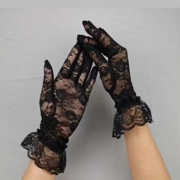 Black lace gloves with floral pattern and ruffled cuffs used as a studio photoshoot accessory.
