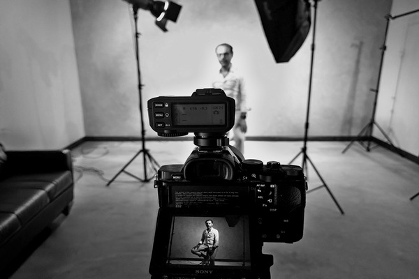 DSLR camera capturing a male model at Boudoir Studio with visible live preview on screen