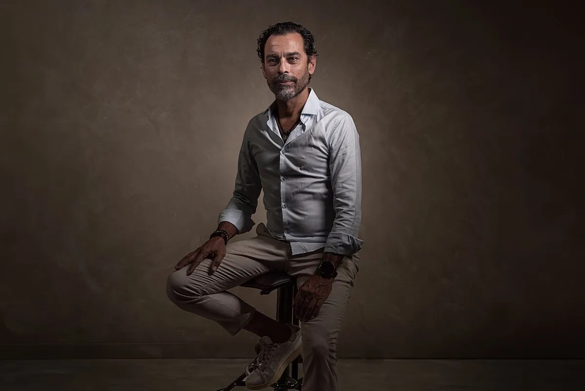 Finished studio portrait of a man seated against a textured background at Boudoir Studio